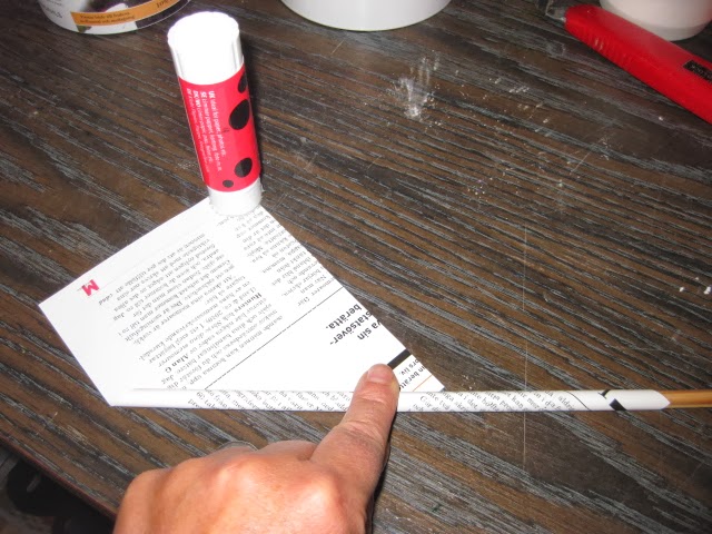 После того как у вас останется небольшой уголок от страницы, смажьте его клеем-карандашом и закончите изготовление заготовки